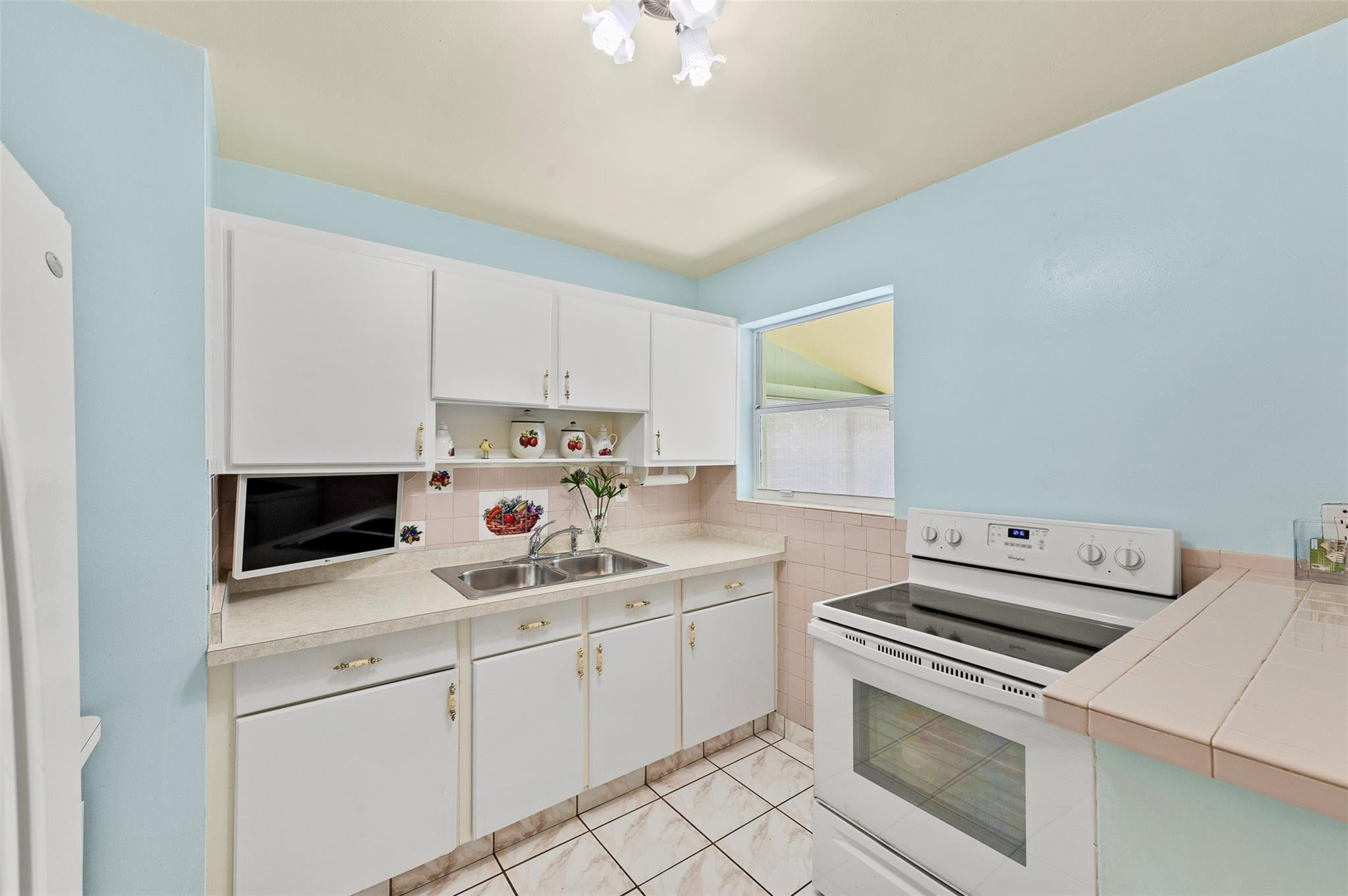946 Alamanda Road West Palm Beach, FL 33405 - Photo 38 of 56 a kitchen with a sink dishwasher stove and white cabinets