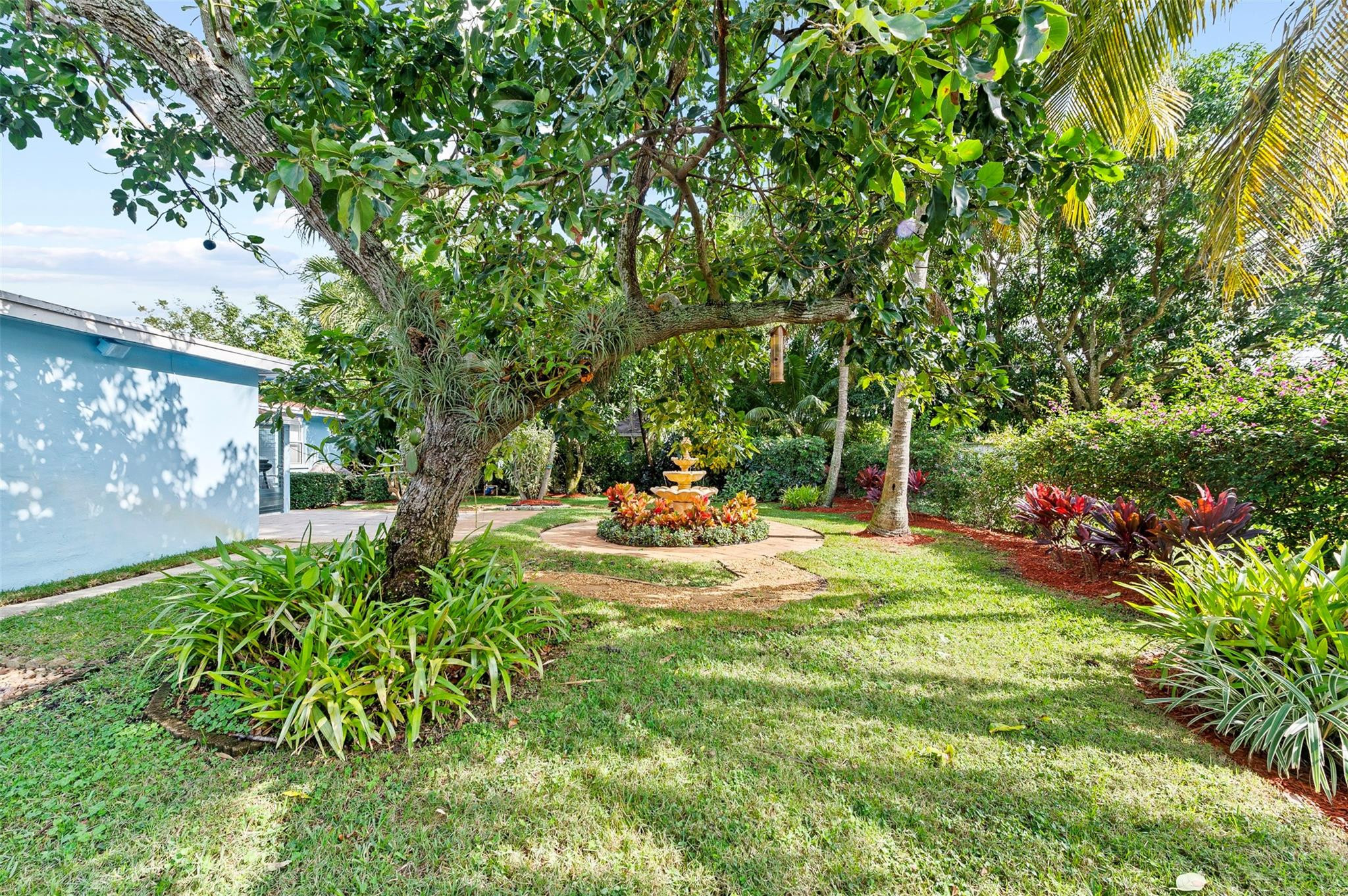 946 Alamanda Road West Palm Beach, FL 33405 - Photo 53 of 56 a backyard of a house with table and chairs plants and large trees