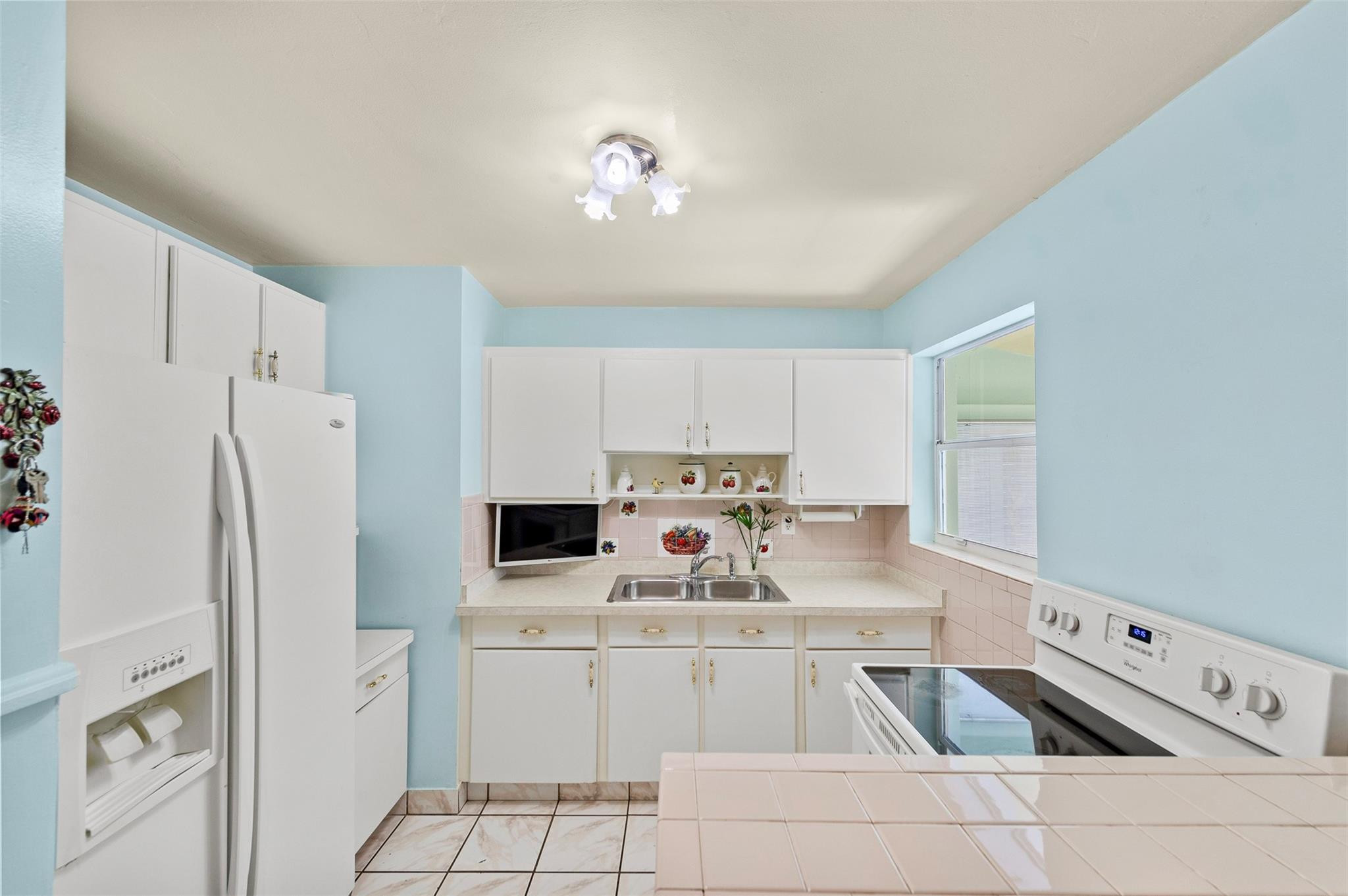 946 Alamanda Road West Palm Beach, FL 33405 - Photo 9 of 56 a kitchen with stainless steel appliances granite countertop a refrigerator sink and white cabinets