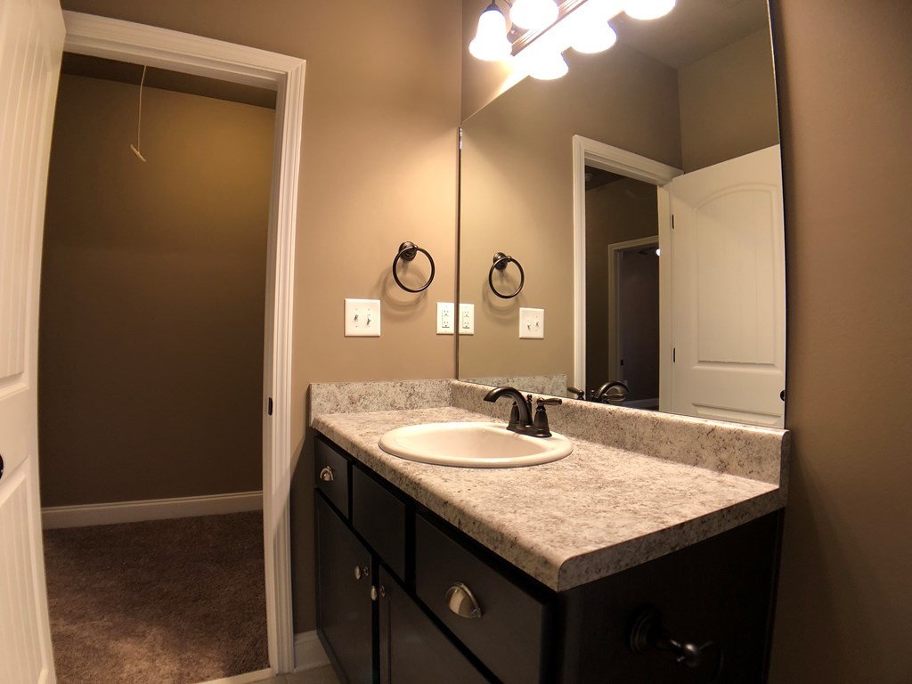 330 Walnut Grove Road Gray, GA 31032 - Photo 31 of 42 a bathroom with a granite countertop sink and a mirror