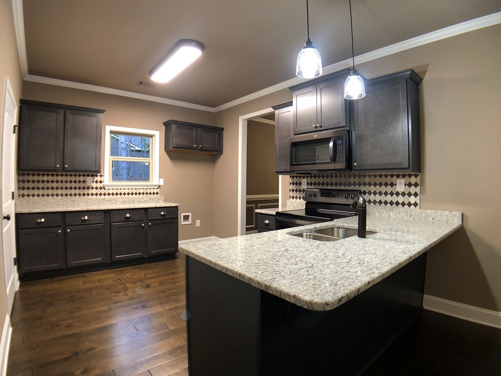 330 Walnut Grove Road Gray, GA 31032 - Photo 7 of 42 a kitchen with granite countertop stainless steel appliances and wooden cabinets