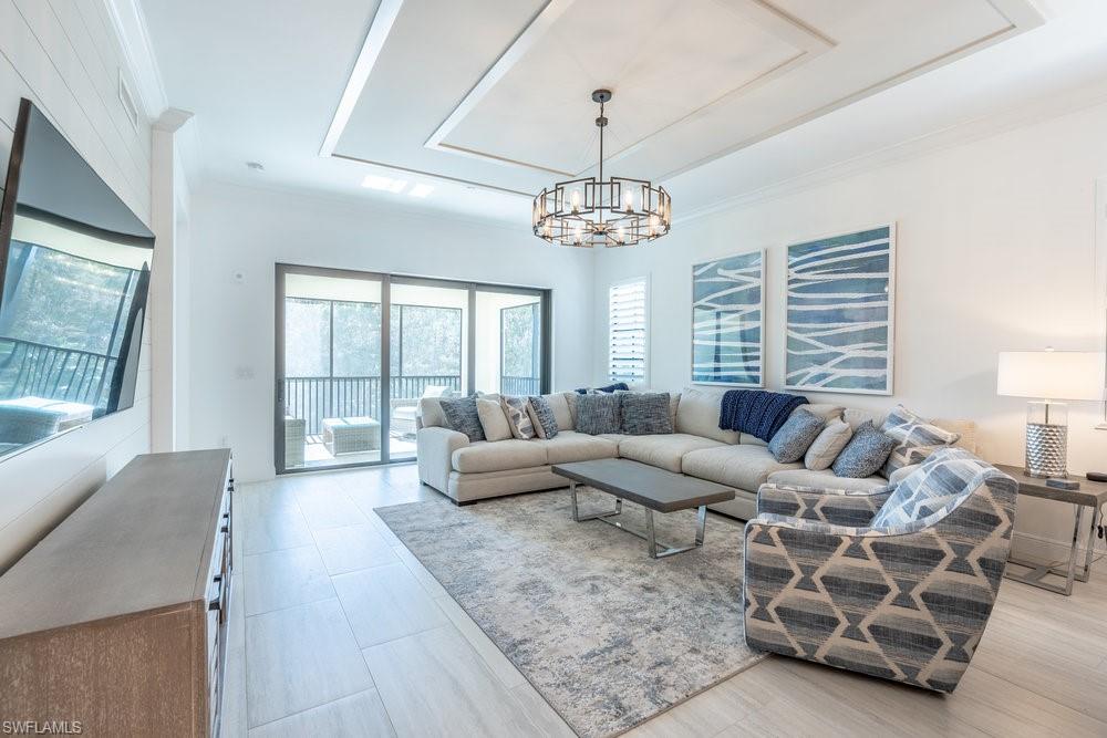 16364 Viansa Way, Unit 202 Naples, FL 34110 - Photo 11 of 39 a living room with furniture and a chandelier