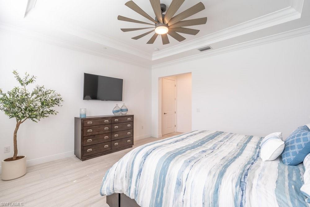 16364 Viansa Way, Unit 202 Naples, FL 34110 - Photo 13 of 39 a bedroom with a bed and a flat screen tv