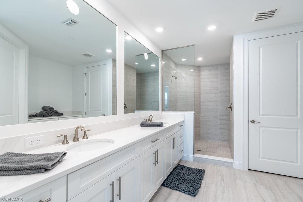 16364 Viansa Way, Unit 202 Naples, FL 34110 - Photo 14 of 39 a spacious bathroom with a granite countertop double vanity sink a mirror and a shower