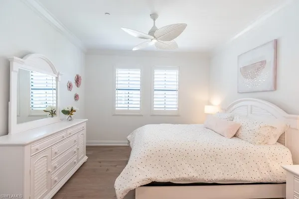 a bedroom with a bed a chandelier and a window