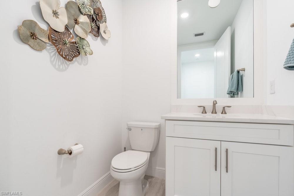 16364 Viansa Way, Unit 202 Naples, FL 34110 - Photo 17 of 39 a bathroom with a toilet sink vanity and mirror