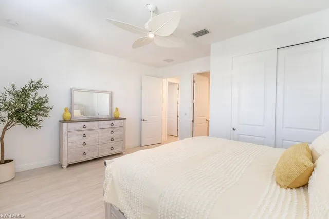 a spacious bedroom with a bed and a potted plant