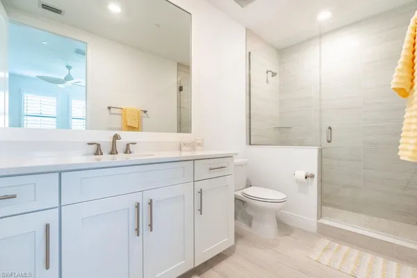 a bathroom with a double vanity sink toilet and shower