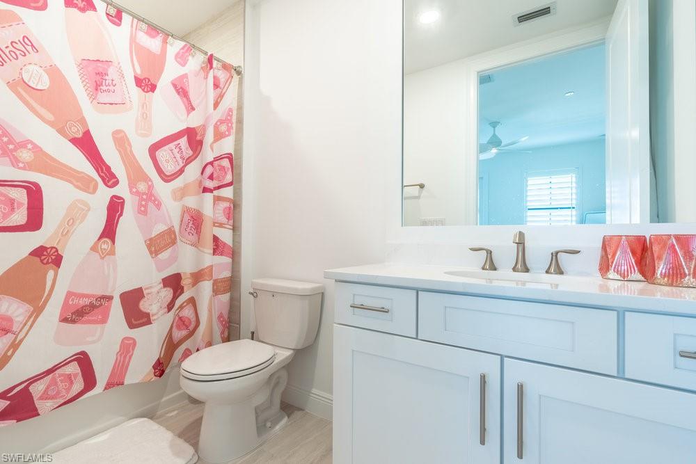 16364 Viansa Way, Unit 202 Naples, FL 34110 - Photo 23 of 39 a bathroom with a toilet sink vanity and mirror