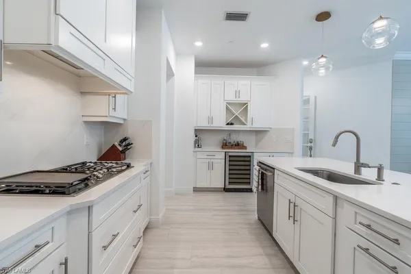 a kitchen with stainless steel appliances a sink stove and cabinets