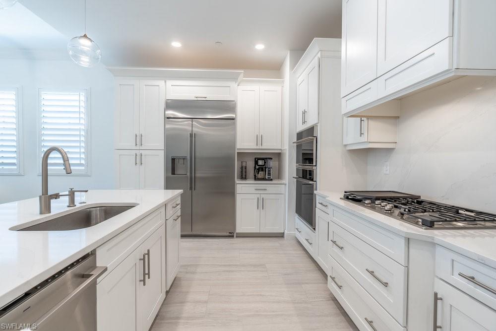 16364 Viansa Way, Unit 202 Naples, FL 34110 - Photo 6 of 39 a kitchen with stainless steel appliances granite countertop a sink stove and refrigerator