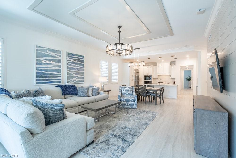 16364 Viansa Way, Unit 202 Naples, FL 34110 - Photo 10 of 39 a living room with furniture a dining table and a chandelier