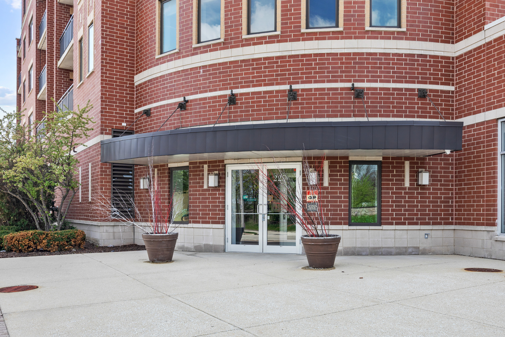 225 Main Street, Unit 216 Roselle, IL 60172 - Photo 3 of 20 front view of a brick house with potted plants