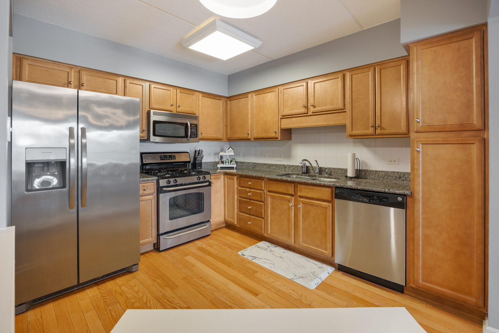225 Main Street, Unit 216 Roselle, IL 60172 - Photo 9 of 20 a kitchen with a refrigerator stove top oven and sink