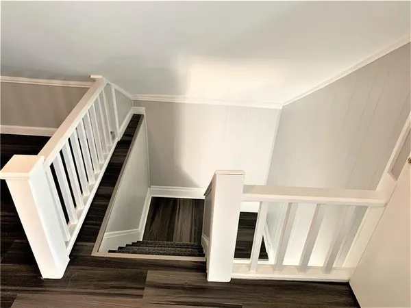 a view of staircase with white walls and railing