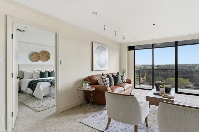 a living room with furniture and a floor to ceiling window