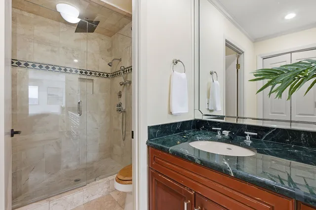 a bathroom with a granite countertop sink a mirror a bathtub and shower