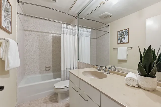 a bathroom with a granite countertop sink toilet and shower