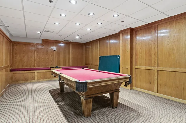 a room with wooden floor pool table and a table