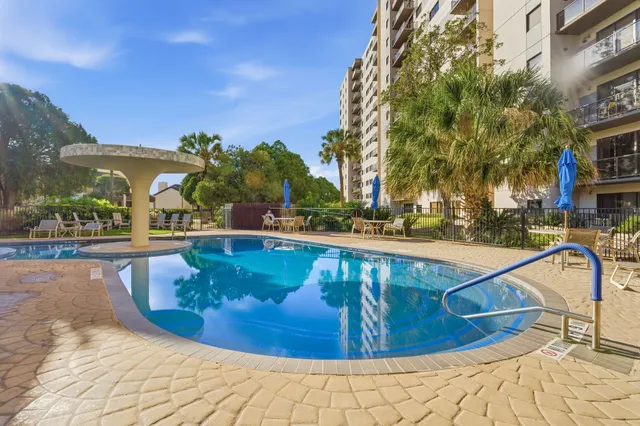 a view of swimming pool with outdoor seating and plants