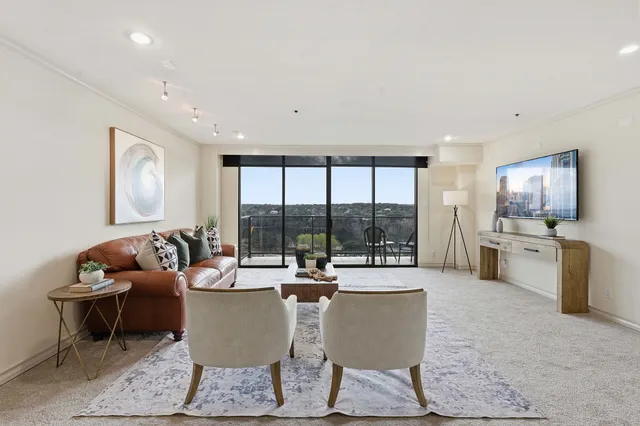 a living room with fireplace furniture and floor to ceiling window