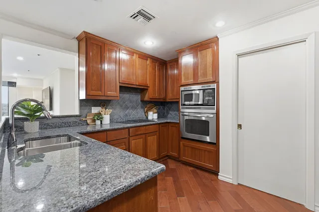 a kitchen with stainless steel appliances granite countertop a sink refrigerator and microwave
