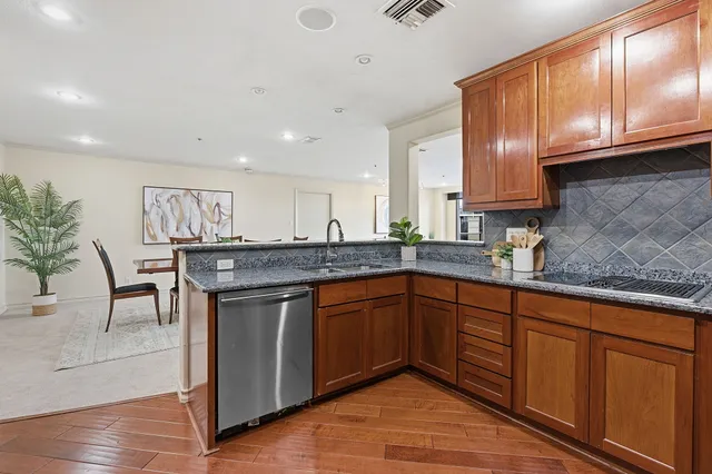 a kitchen with stainless steel appliances granite countertop wooden cabinets a sink and dishwasher
