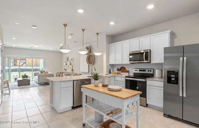 a kitchen with stainless steel appliances granite countertop a sink a stove a microwave a refrigerator and cabinets