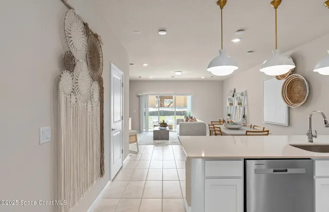 a kitchen with stainless steel appliances a stove a refrigerator a sink a dining table and chairs with wooden floor