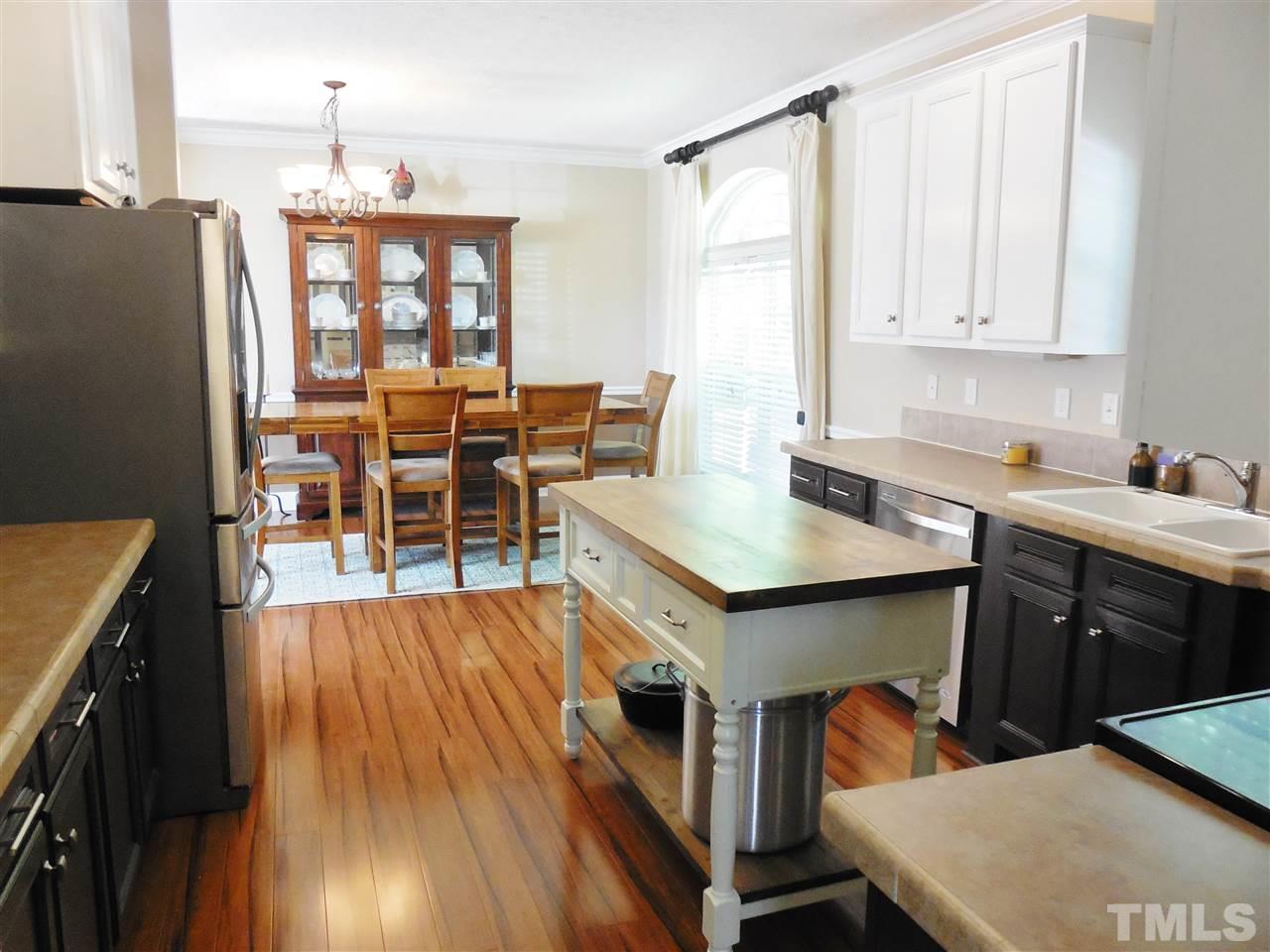 924 Whitt Town Road Roxboro, NC 27574 - Photo 4 of 17 a open kitchen with stainless steel appliances granite countertop a stove refrigerator and a dining table with wooden floor