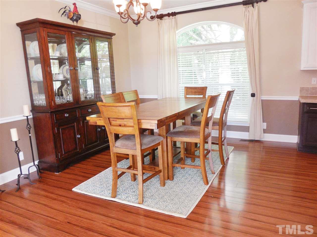 924 Whitt Town Road Roxboro, NC 27574 - Photo 8 of 17 a dining room with wooden floor a chandelier a glass table and chairs