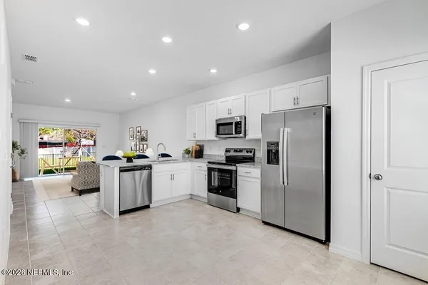 a large kitchen with stainless steel appliances a refrigerator and a stove top oven