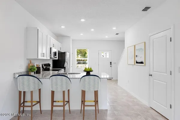 a view of kitchen and kitchen with refrigerator