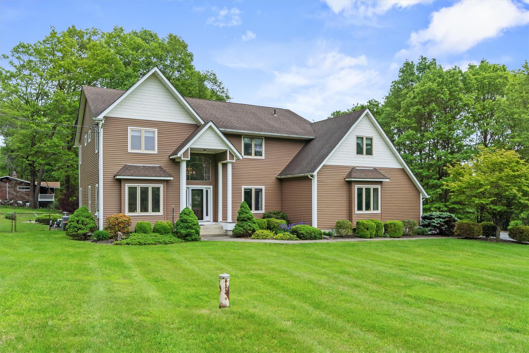 a front view of house with yard and green space