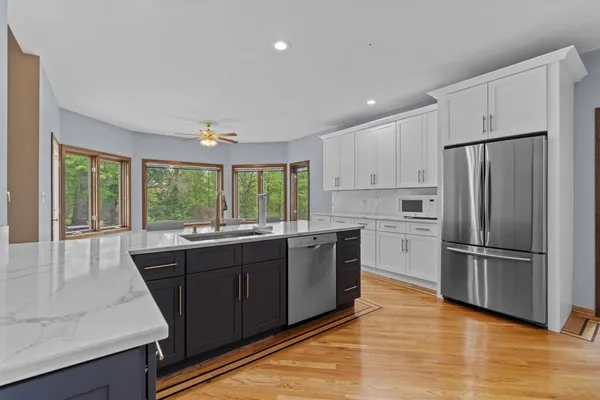 a spacious bathroom with a granite countertop tub sink and window
