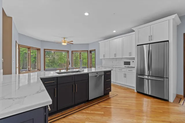 a spacious bathroom with a granite countertop tub sink and window