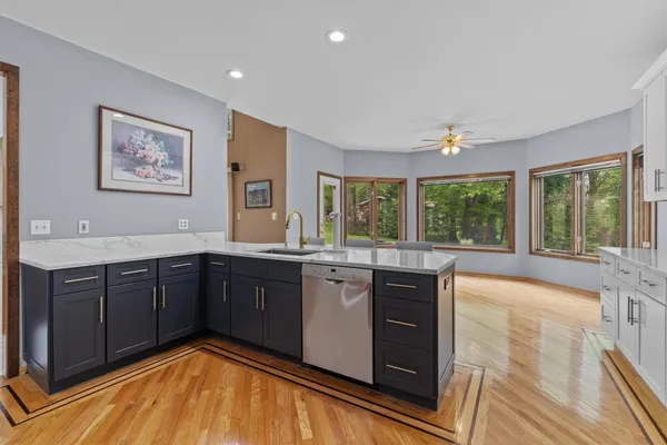 a view of an empty room with a window and a kitchen area