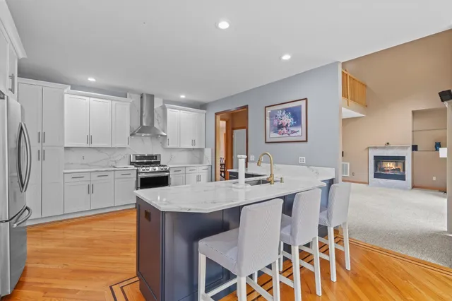 a kitchen with granite countertop white cabinets and stainless steel appliances
