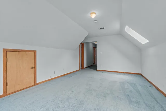 a bedroom with a bed a chandelier and dresser