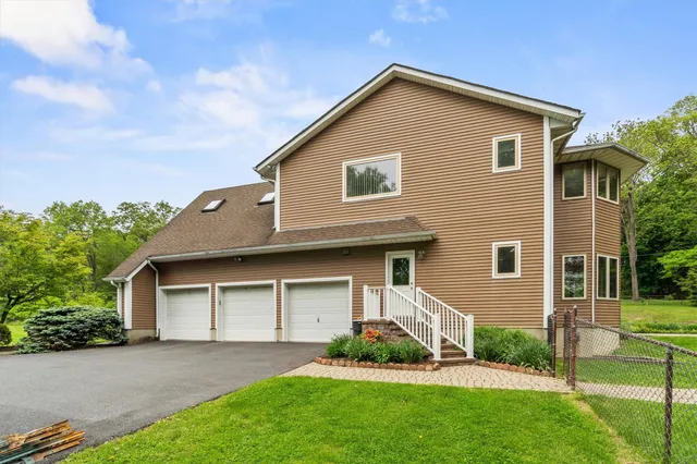 a view of pool with lawn chairs and plants