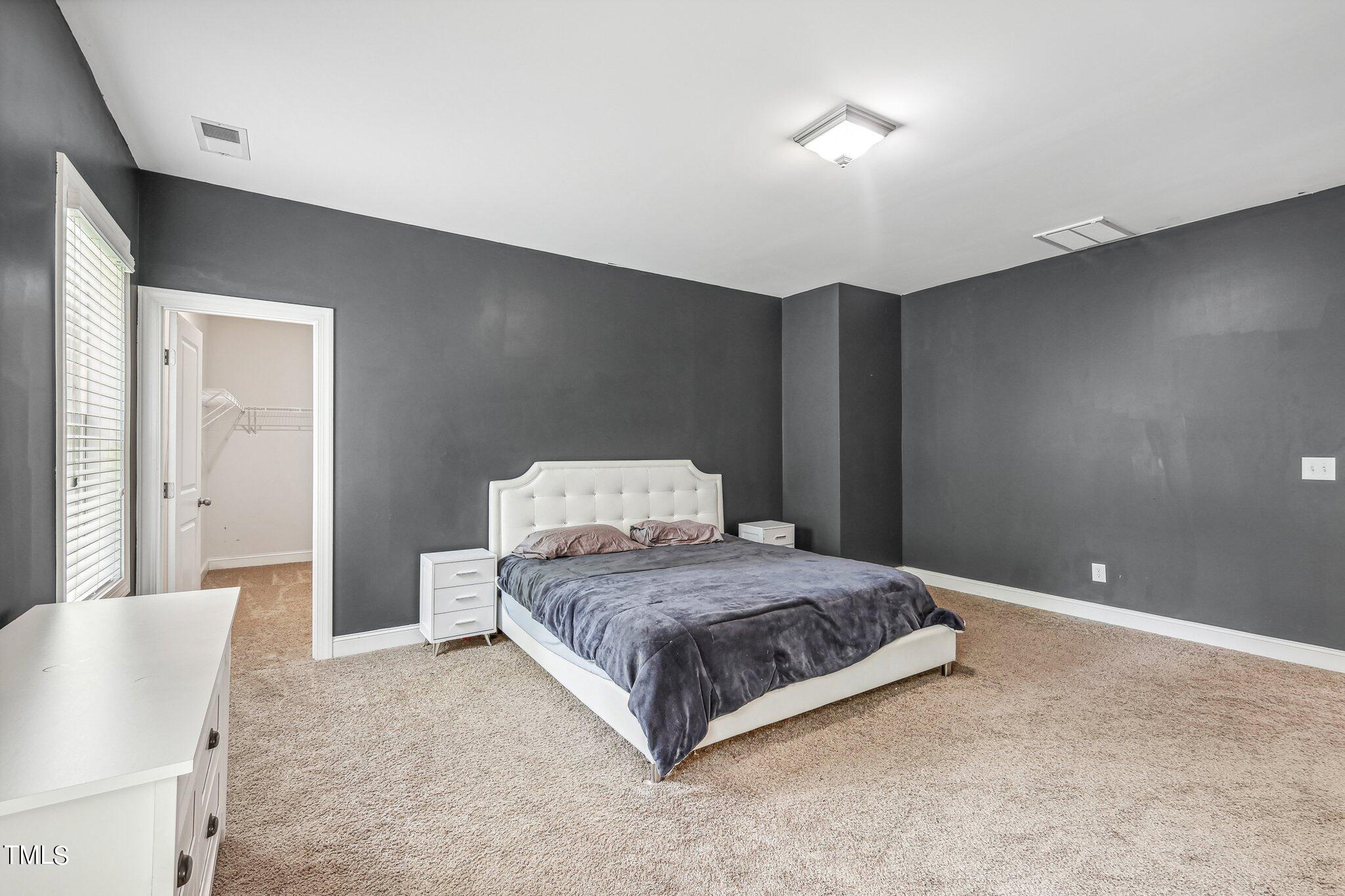 1516 Yakimas Road Raleigh, NC 27603 - Photo 23 of 27 a bedroom with a bed and a lamp