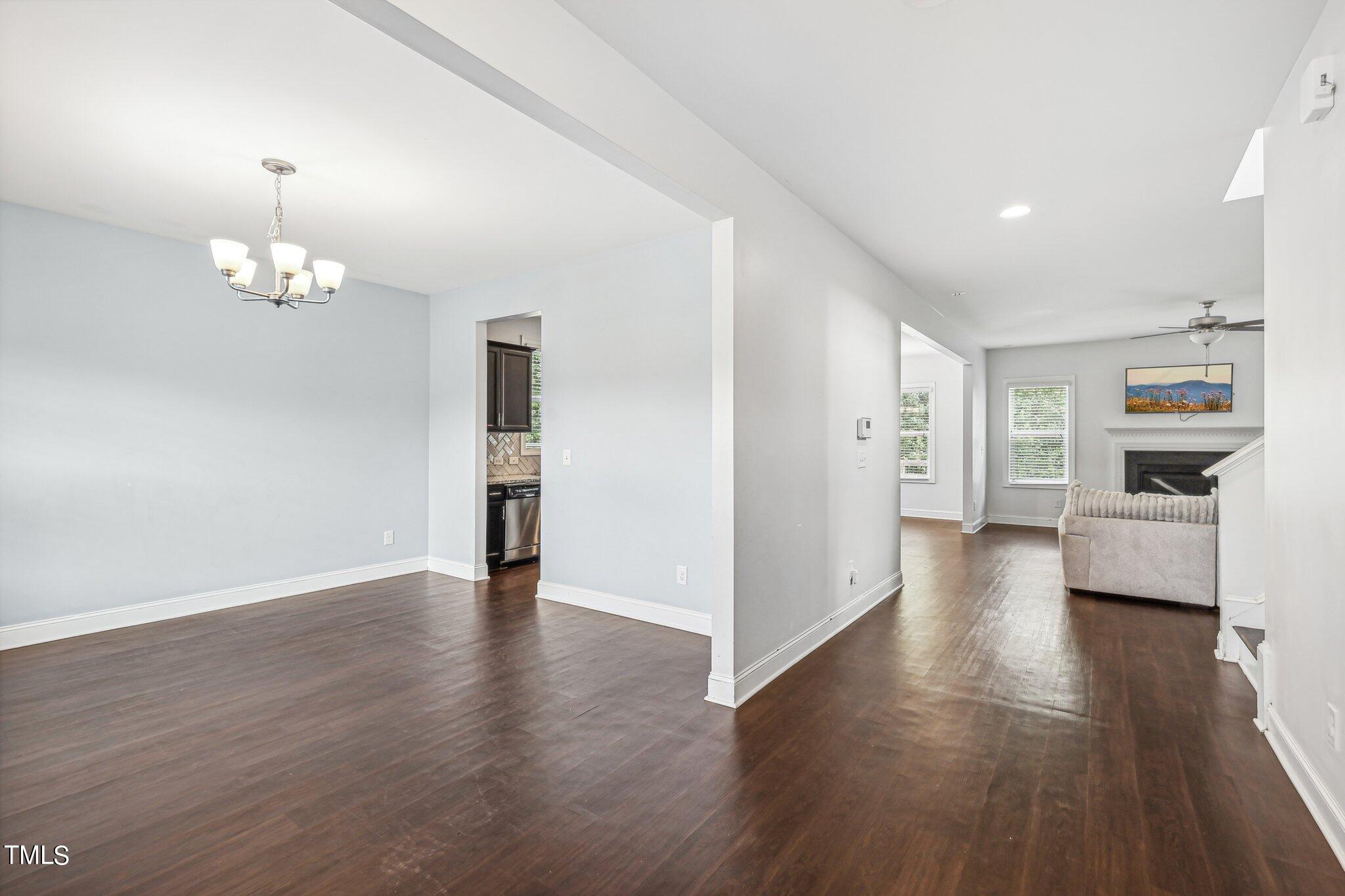 1516 Yakimas Road Raleigh, NC 27603 - Photo 8 of 27 an empty room with wooden floor and kitchen