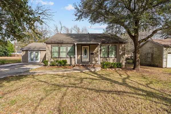 a front view of a house with a garden and trees