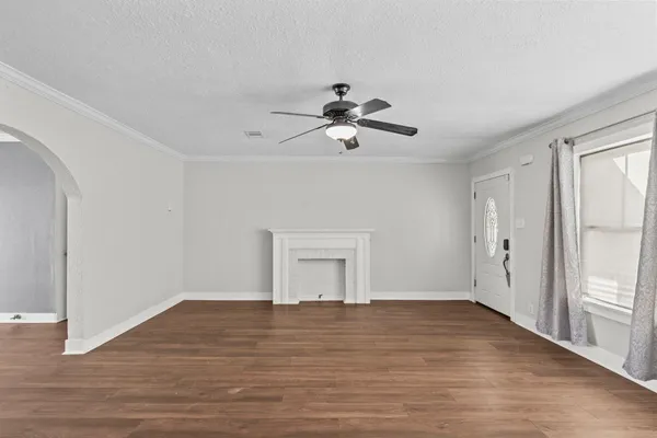 a view of empty room with wooden floor and ceiling fan