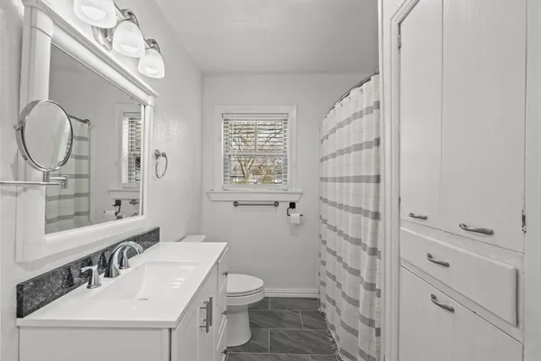 a bathroom with a sink a toilet and shower
