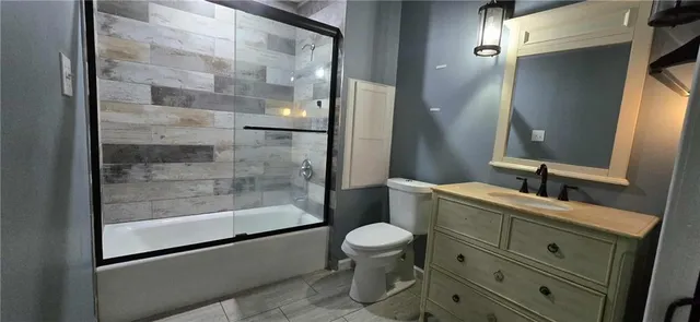 a bathroom with a bathtub shower sink mirror and toilet