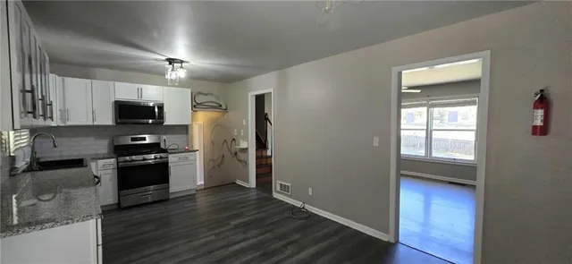 a kitchen with granite countertop wooden floors and stainless steel appliances