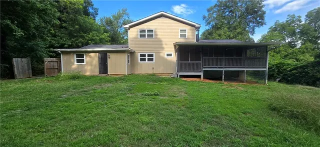 a front view of a house with a yard and trees