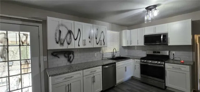 a kitchen with granite countertop a stove sink and microwave