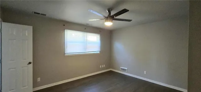 an empty room with a window and a fan